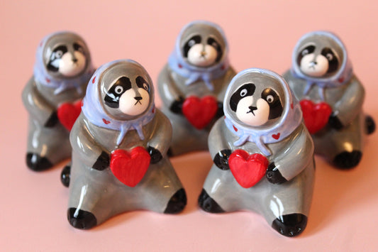 Raccoon holding a heart