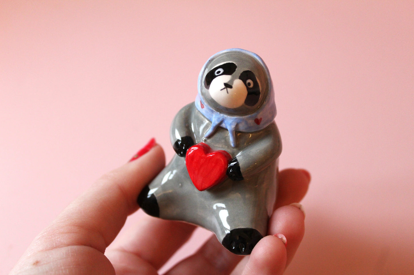 Raccoon holding a heart